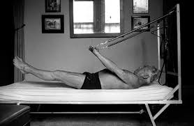 Joe Pilates agli albori delle sue invenzioni su letto e molle